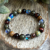 Healing crystal bracelet with Black Aura Quartz, Chrysocolla, Bloodstone and Tigers eye promoting resilience and inner peace. 