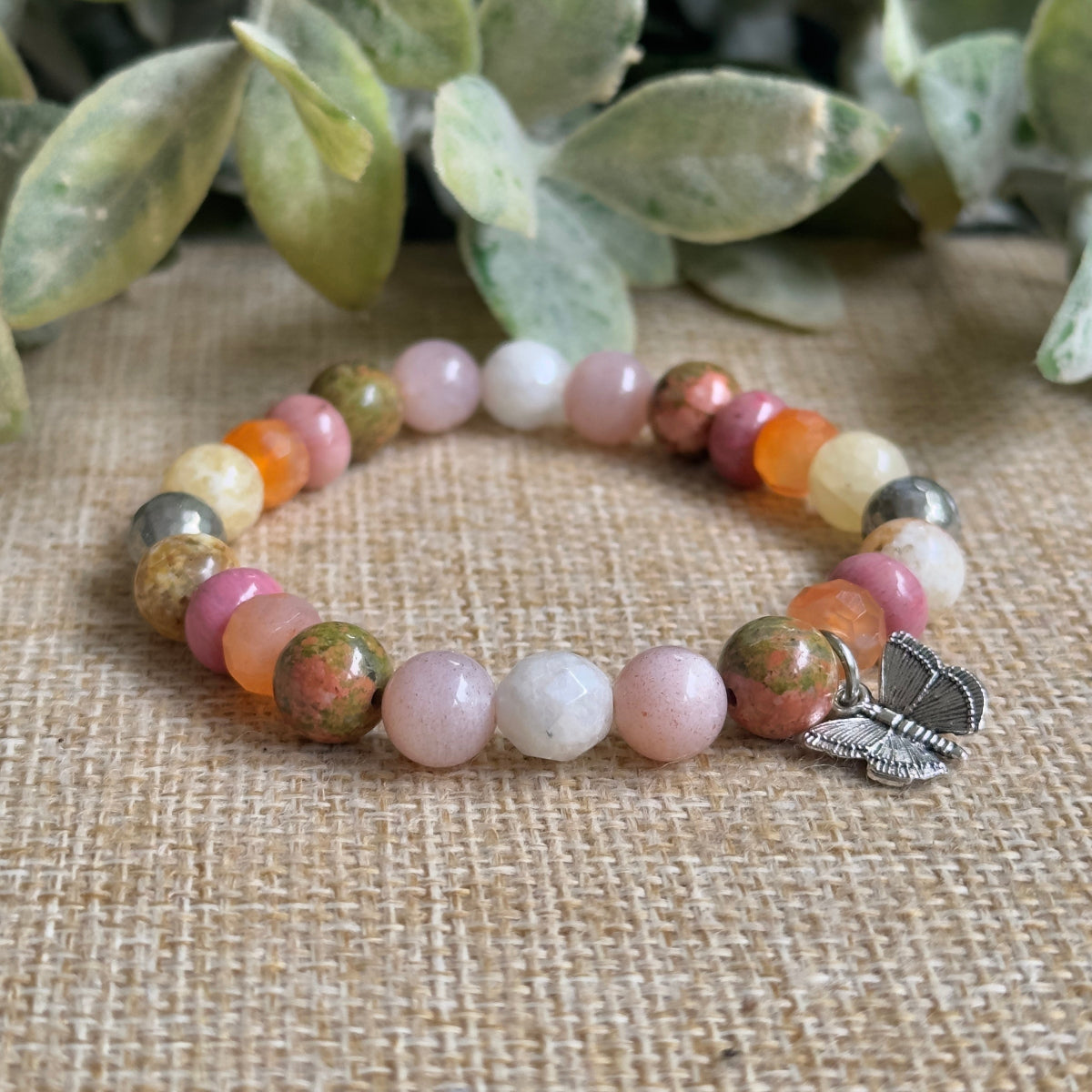 Close up detail of round pyrite peach moonstone mystic moonstone carnelian rhodonite and unakite beads.