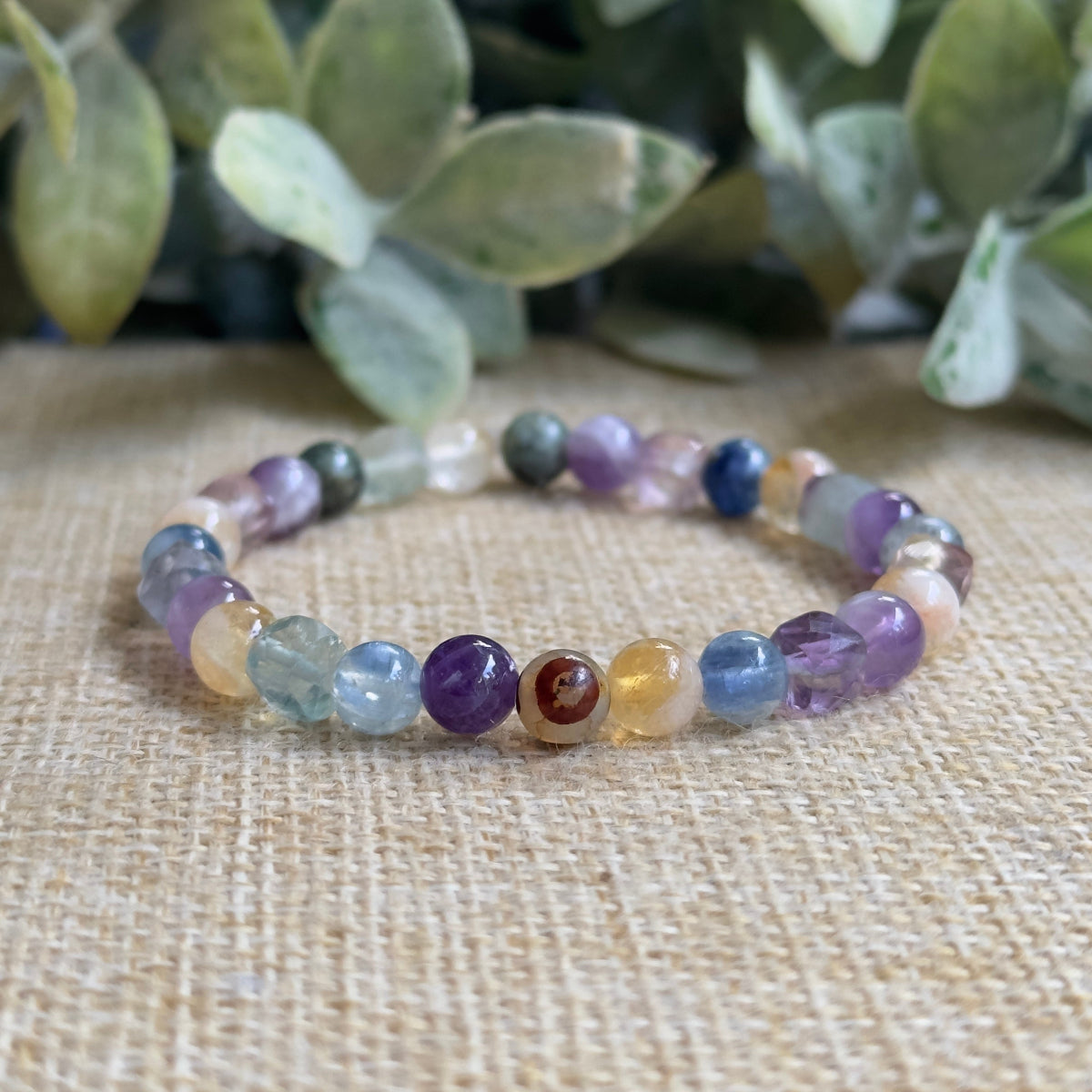 Conscious Evolution healing crystal bracelet featuring purple amethyst yellow citrine blue kyanite rainbow fluorite beads