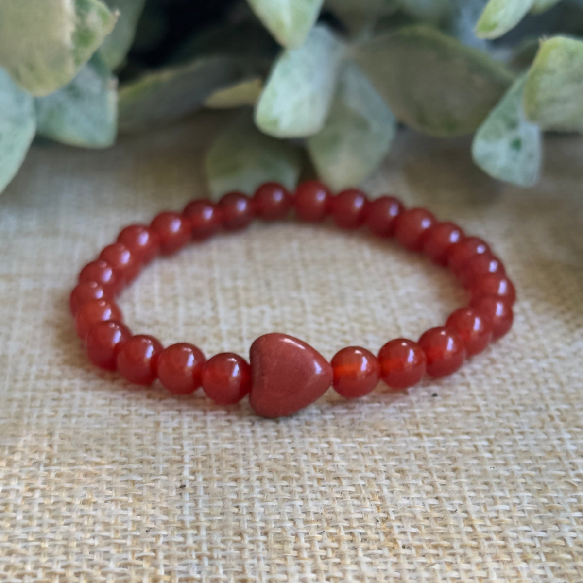 Macro view of polished 6mm red carnelian gemstones showcasing natural orange and red crystal textures.