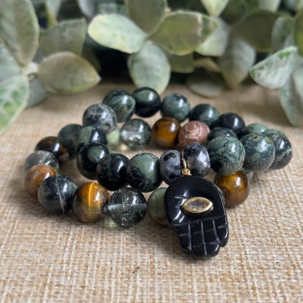Flat lay display of a natural crystal healing bracelet featuring raw texture Madagascar jasper and Norwegian larvikite beads unisex Stacker gemstone bracelet