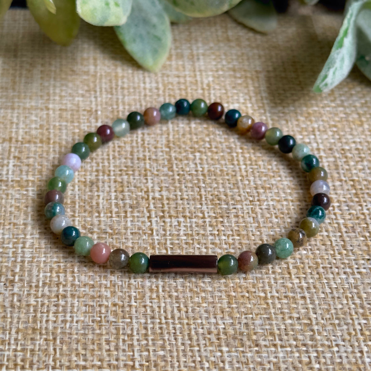 shot of natural green Indian Agate beads and an iridescent brown Mother of Pearl cylindrical tube bead.