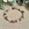 Attracting Love Mini Bracelet featuring Rose Quartz, Strawberry Quartz, Prehnite, and Green Garnet stones that promote joy, self-worth, and divine alignment in love, with an optional silver Evil Eye charm for protection.