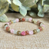 Attracting Love Mini Bracelet with Rose Quartz, heart-shaped Rhodonite, Green Garnet, Strawberry Quartz, Prehnite, and optional silver Evil Eye charm for attracting genuine love and emotional healing.