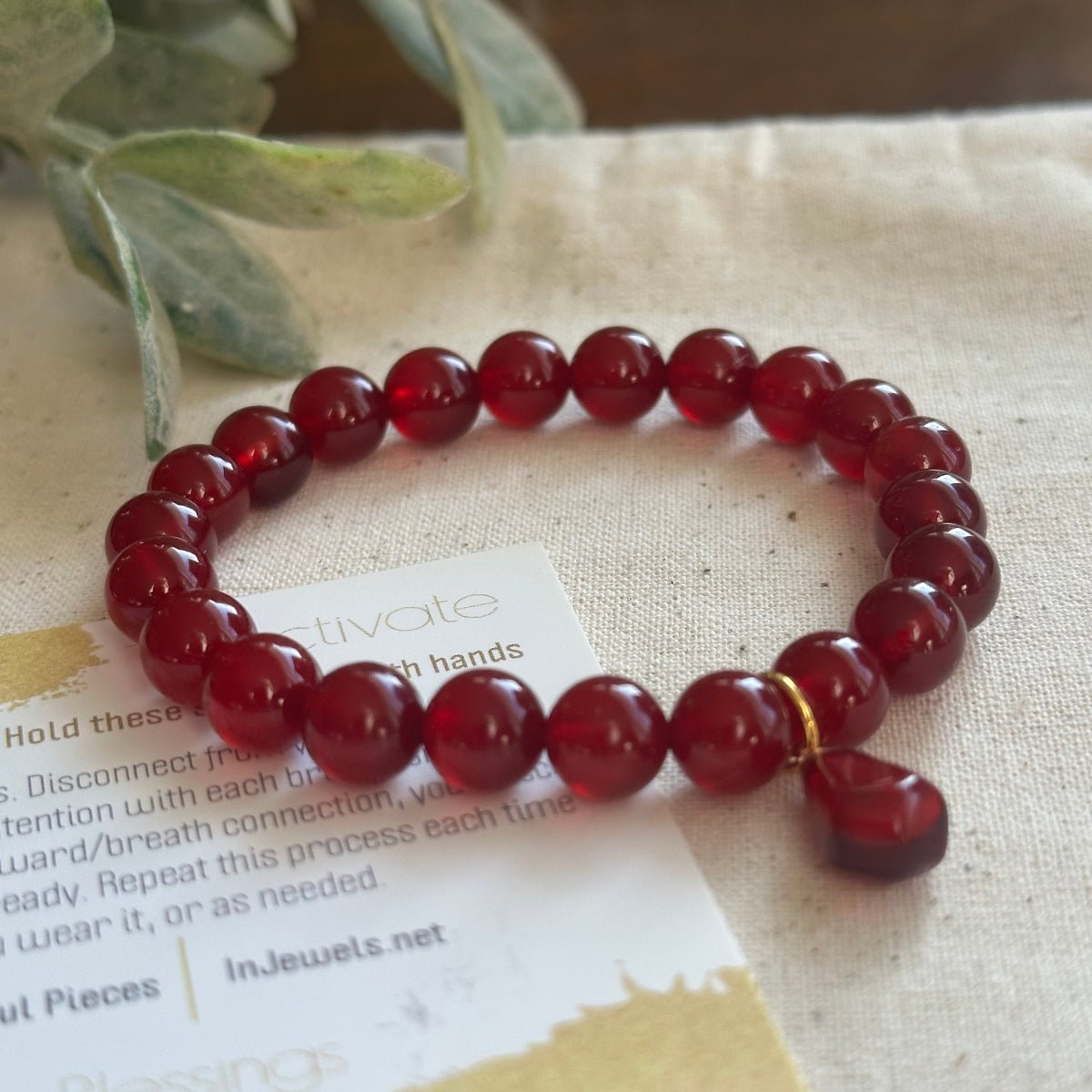 Red jade beaded bracelet with red glass pomegranate charm