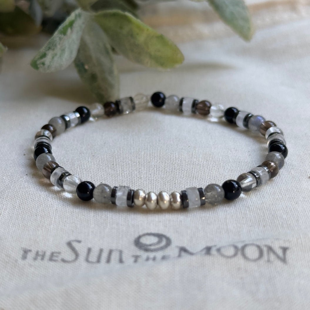 Close-up of a handmade 4mm labradorite and hematite crystal bead bracelet with bright sterling silver accent beads.