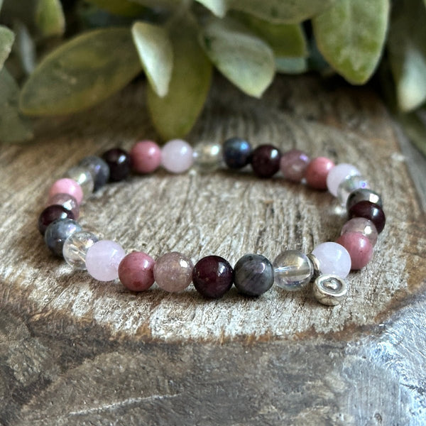 Love Spell Bracelet featuring Rose Quartz, Garnet, and Angel Aura Quartz with a sterling silver heart charm for love and passion.