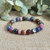Roots and Wings chakra gemstone bracelet with rich jewel-toned stones symbolizing balance and evolution