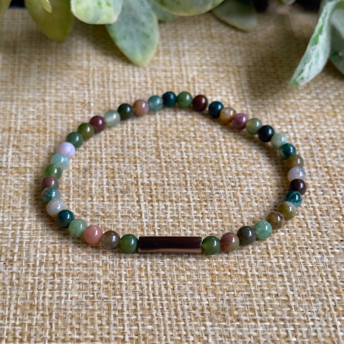 shot of natural green Indian Agate beads and an iridescent brown Mother of Pearl cylindrical tube bead.